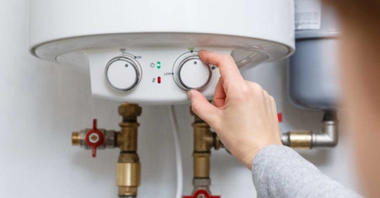 person adjusting electric water heater setting