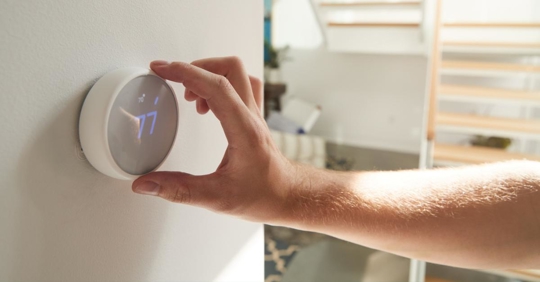 Male Hand Adjusting Digital Thermostat At Home