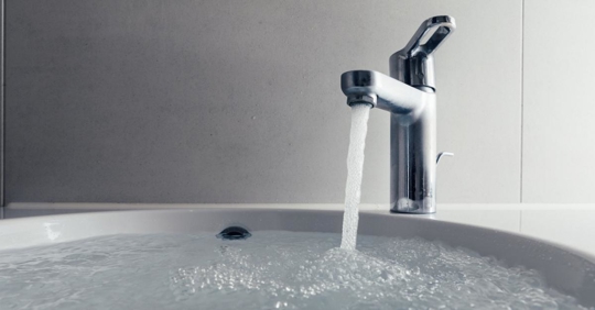 Faucet with flowing water in wash sink